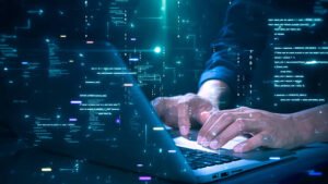 Persona usando laptop y smartphone mientras activa autenticación multifactor para proteger sus cuentas.