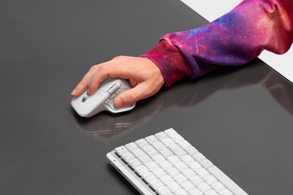 Diseñador utilizando Logitech MX Master 4 con monitor ultrawide y tablet gráfica