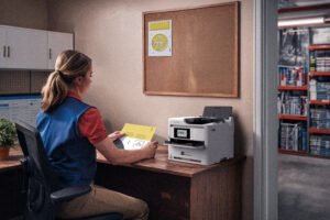 Vista lateral de una impresora multifuncional Epson WorkForce blanca con tanques de tinta visibles para oficinas con toner free