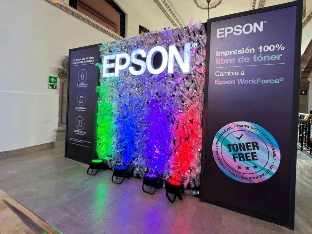 Empleada de oficina revisando documentos impresos junto a un equipo corporativo compacto con toner free